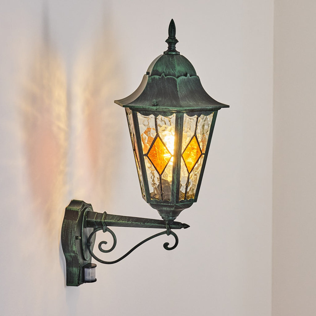Warm, inviting illumination shines from stained glass panels and greenish patina finish.