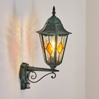 Warm, inviting illumination shines from stained glass panels and greenish patina finish.