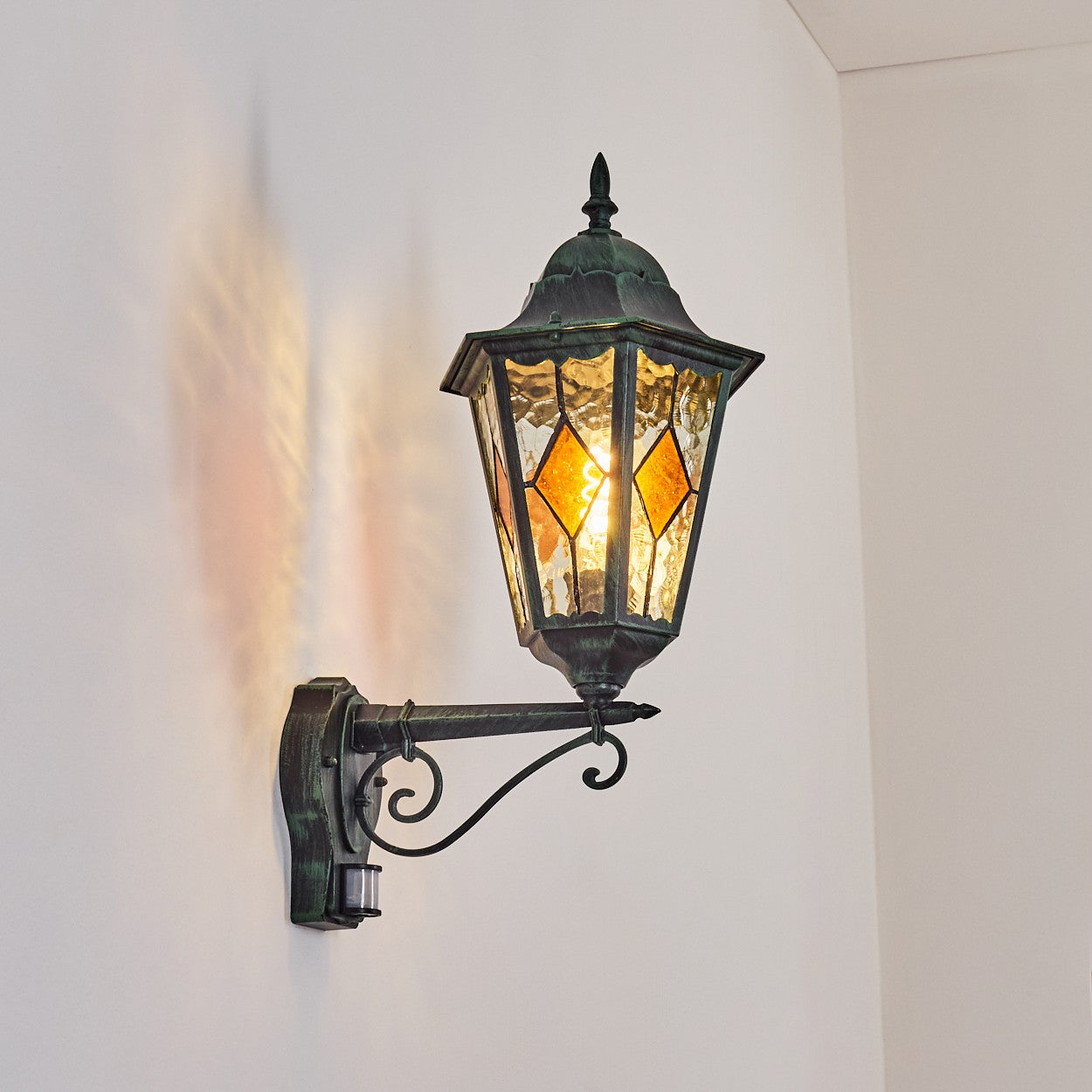 Soft light glows through stained glass panels, creating gentle patterns against the white wall.