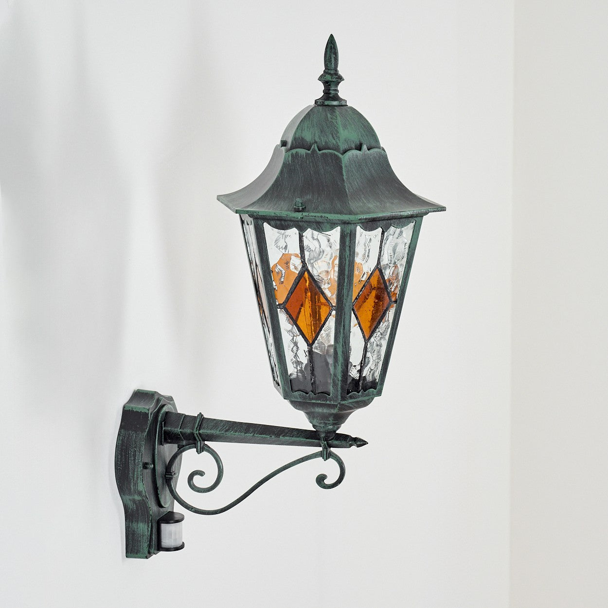 The ORLUNE wall light emits warm, vintage glow from amber diamond panels.