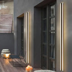 Grande applique murale LED extérieure noire ultra-moderne, parfaitement intégrée à la façade grise.